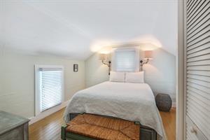Queen bedroom includes dresser and bedside lighting