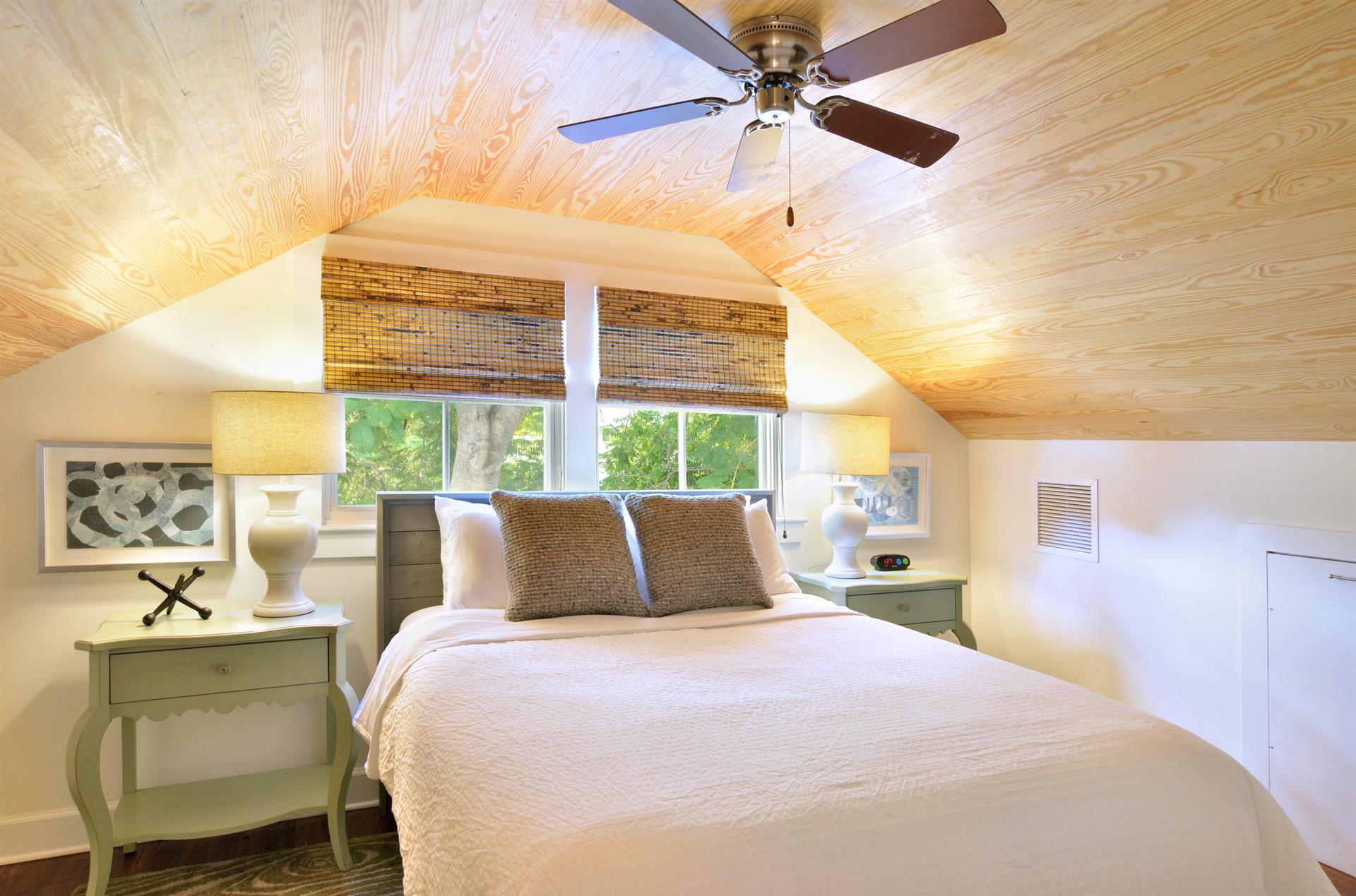 Second floor queen bedroom with dual night stands and lighting.