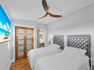 TV, closet, and bedside lighting in this twin or king bedroom.