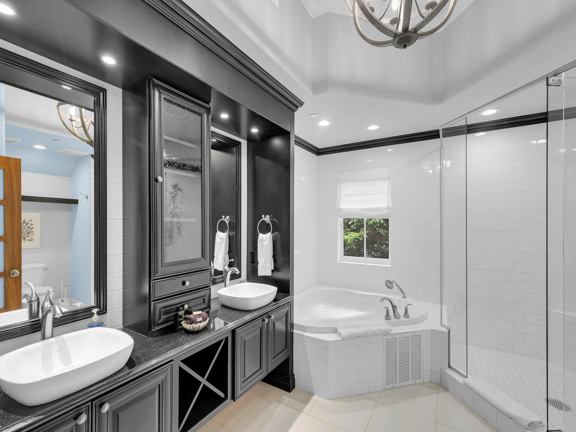 Primary ensuite bath with glass walkin shower and soaking tub.