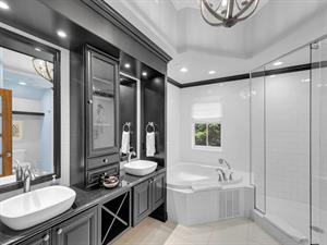 Primary ensuite bath with glass walkin shower and soaking tub.