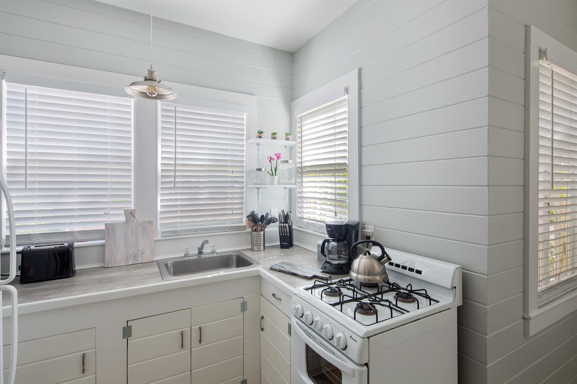 Kitchen includes coffee maker, stove, grill, oven, and toaster.