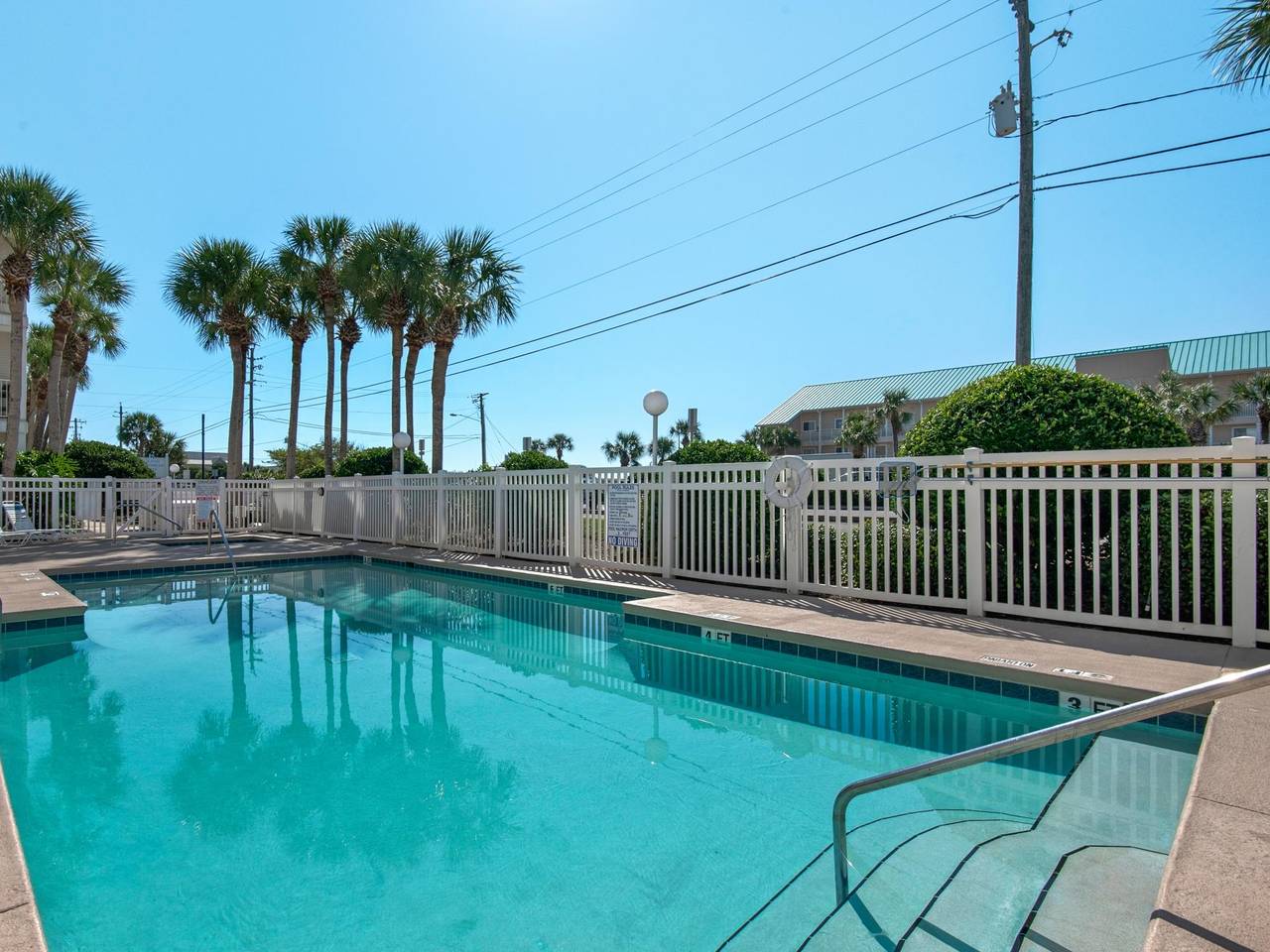 Crystalclear pool surrounded by swaying palm trees offers your perfect tropical escape under sunny Florida skies.
