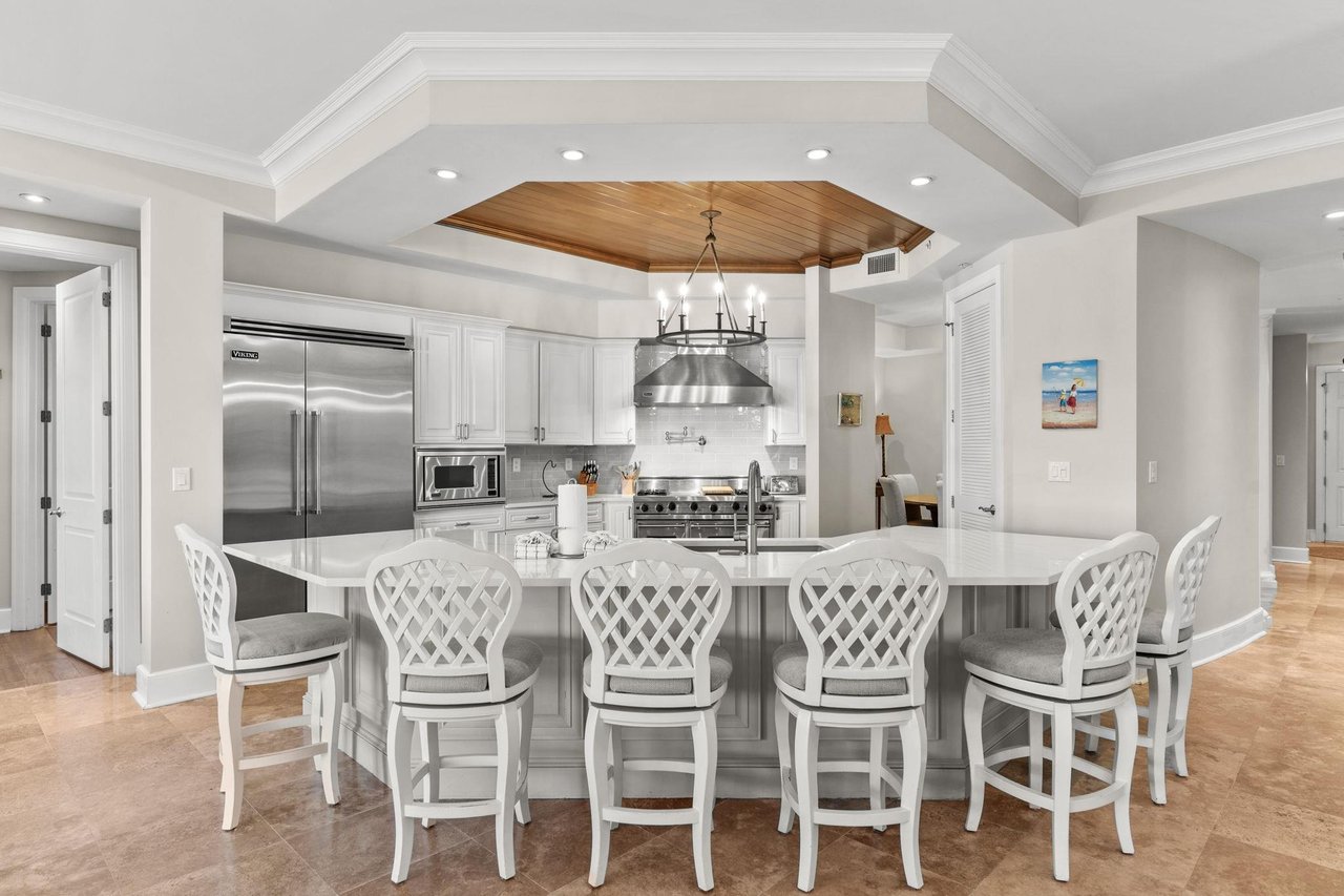 a kitchen with a dining table and white chairs