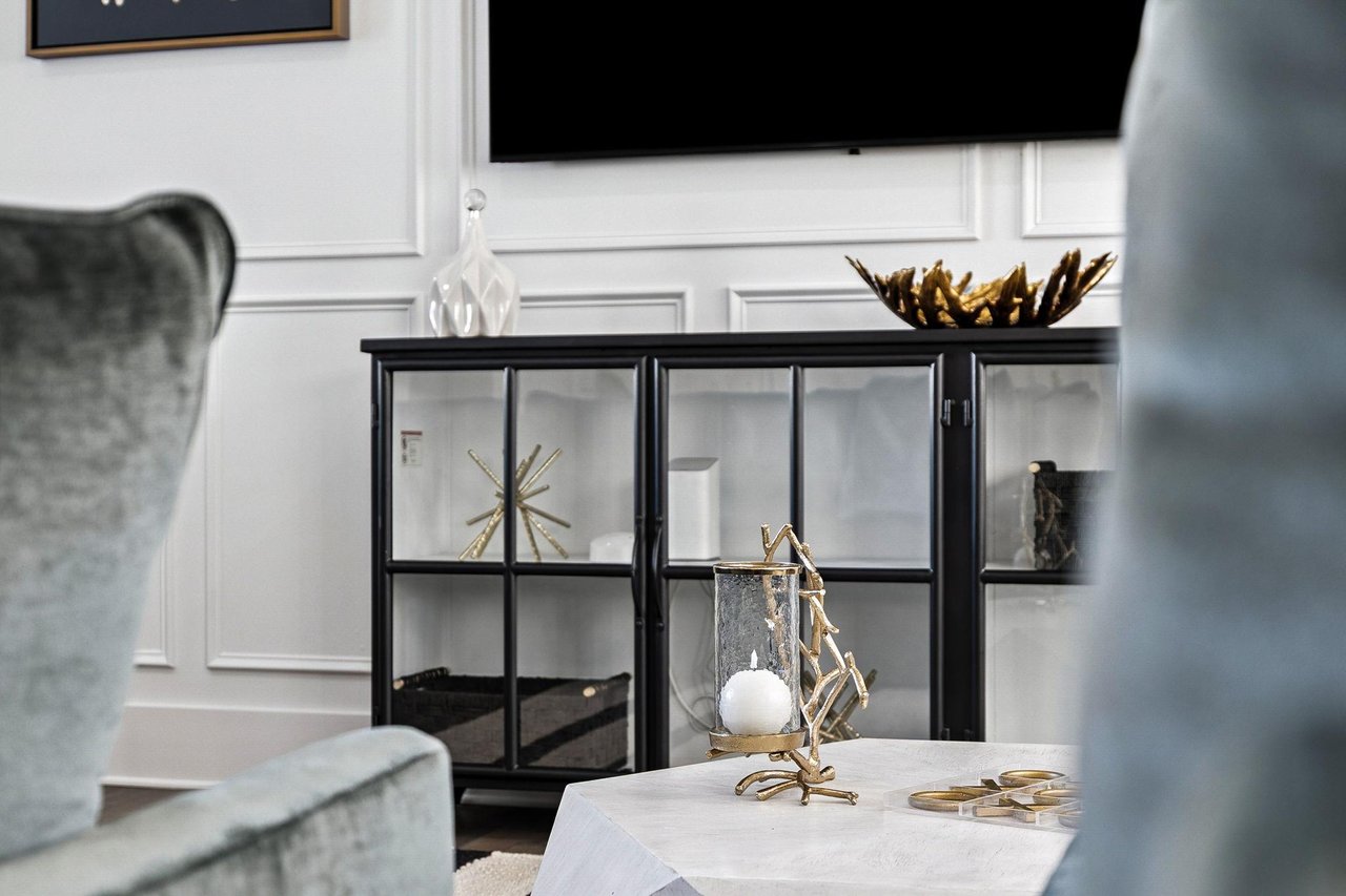 Relax in your elegant living space featuring a stylish glass cabinet and premium entertainment setup for cozy evenings.