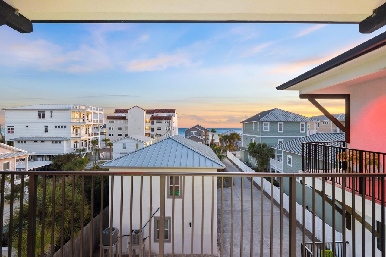 Stunning sunset views of beach houses and coastal architecture from this covered balcony.