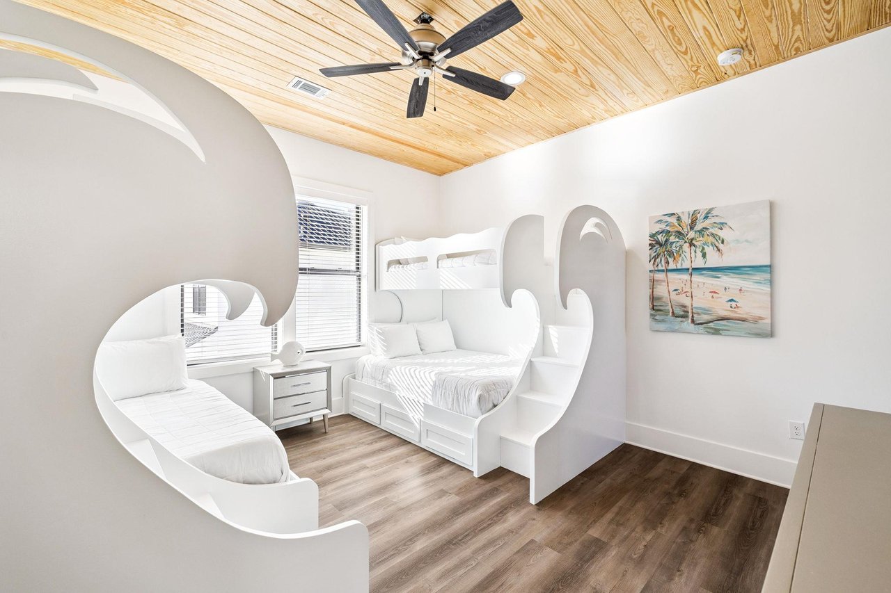 Step into your dreamy bedroom featuring custom curved walls and warm wood ceiling fan keeping you cool during peaceful nights.