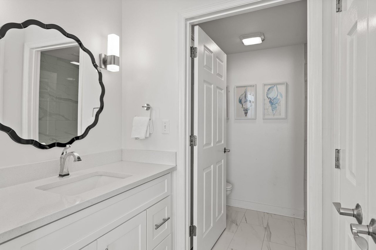 Marble countertops and stylish scalloped mirror equal luxury