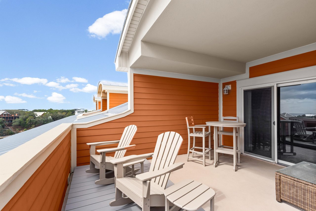 Relax in comfortable Adirondack chairs on this private balcony, where coastal breezes and stunning views create the perfect morning coffee spot.