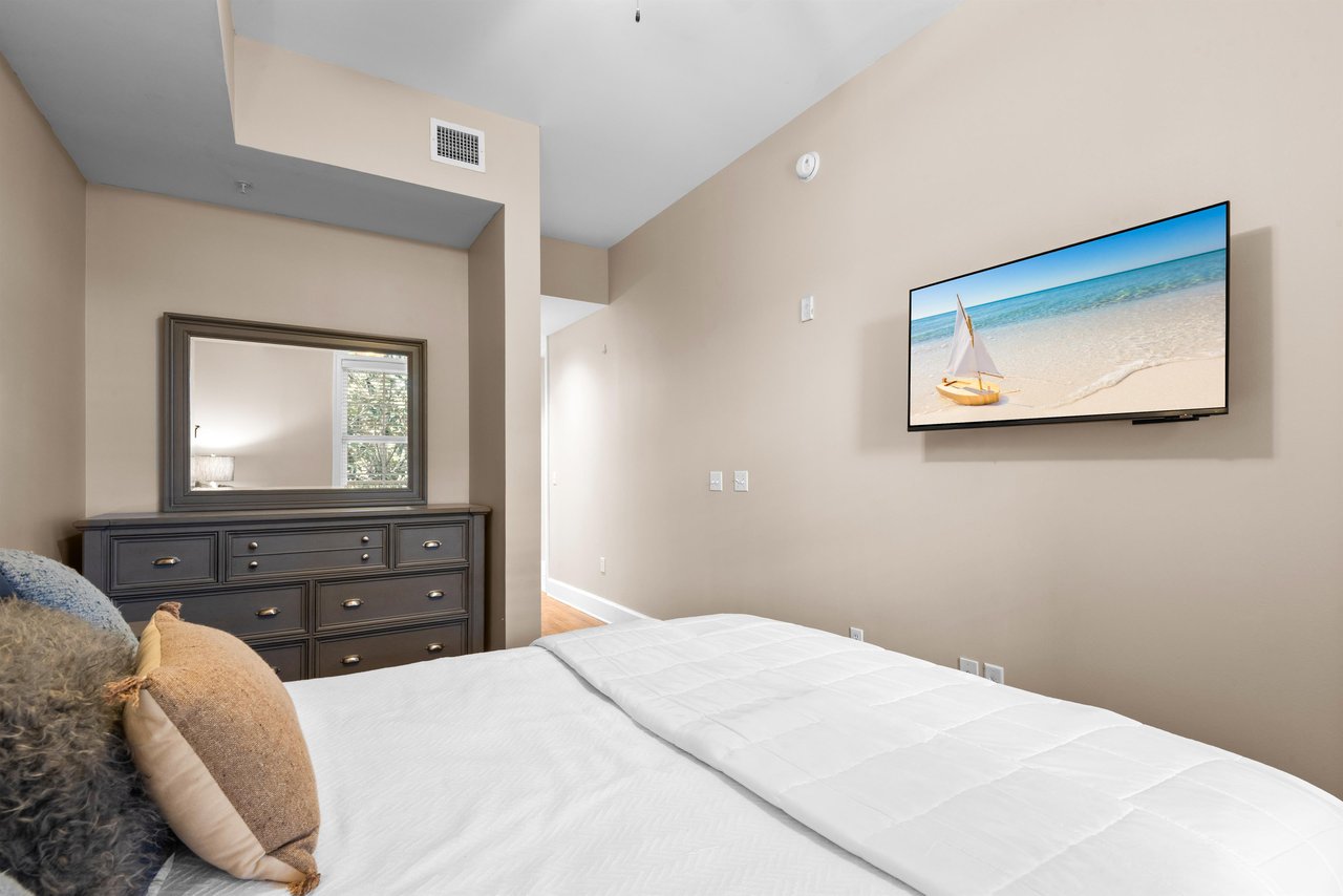 Sink into this plush queen bed while enjoying entertainment on the wallmounted TV, with dresser storage for all your belongings.