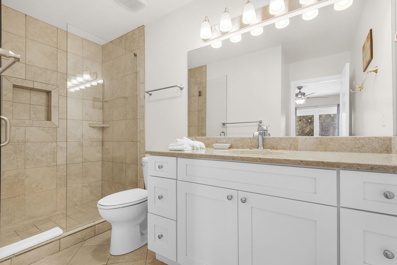 Bathroom 1 features a walkin shower and granite counters