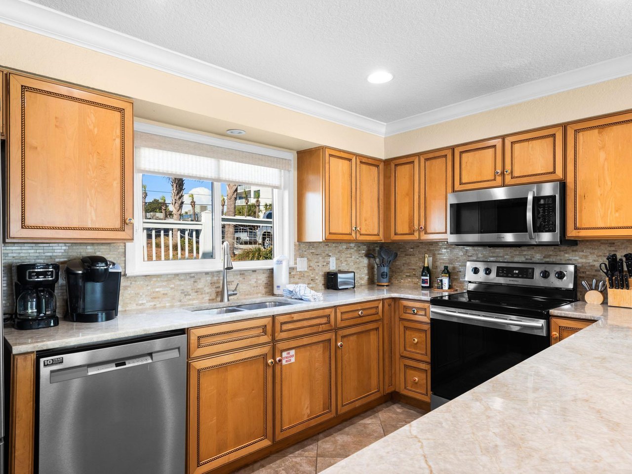 The spacious kitchen features warm wood cabinets, modern appliances, and ample counter space for preparing memorable meals during your stay.