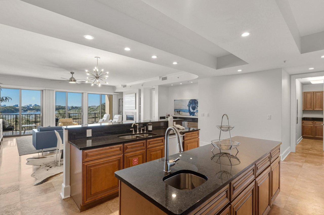Gourmet kitchen features granite countertops and premium appliances, with stunning views beckoning from the living area beyond.