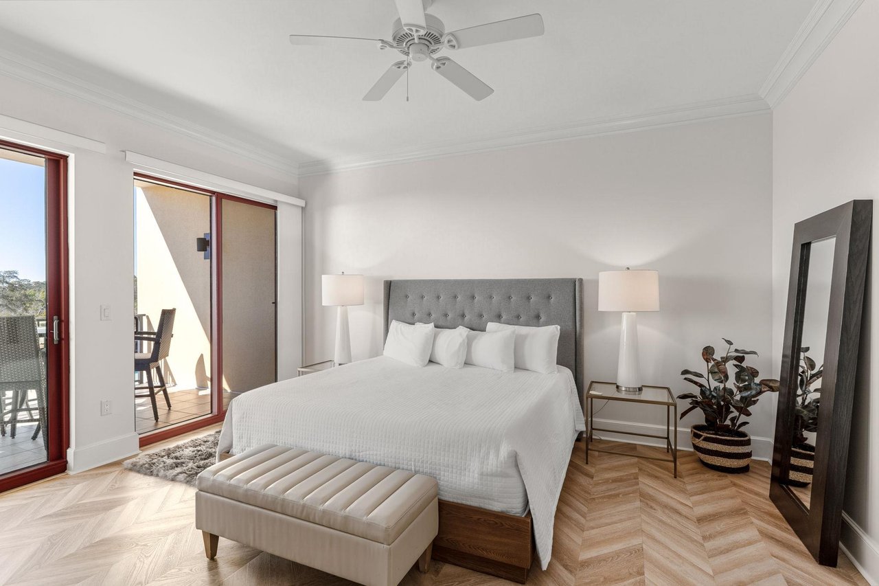 Relax in this elegant gulf front king primary bedroom with plush bedding, and balcony access.