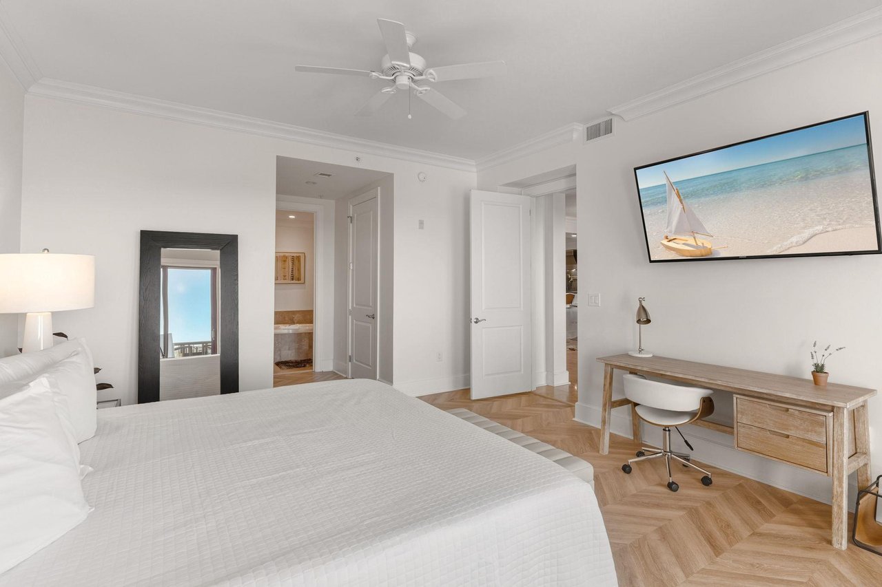 This primary bedroom offers a cozy workspace and beach views, perfect for relaxing after exploring the coast.