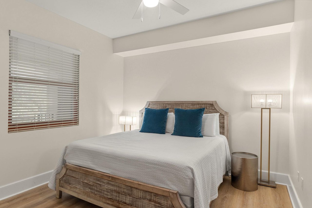 Unwind in this serene king guest bedroom with its plush bedding, coastalinspired accents, and gentle ceiling fan keeping you comfortable all night.