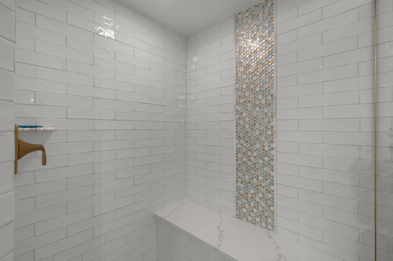 Refresh in a spalike shower with gleaming subway tiles and stunning mosaic accent wall for daily luxury.