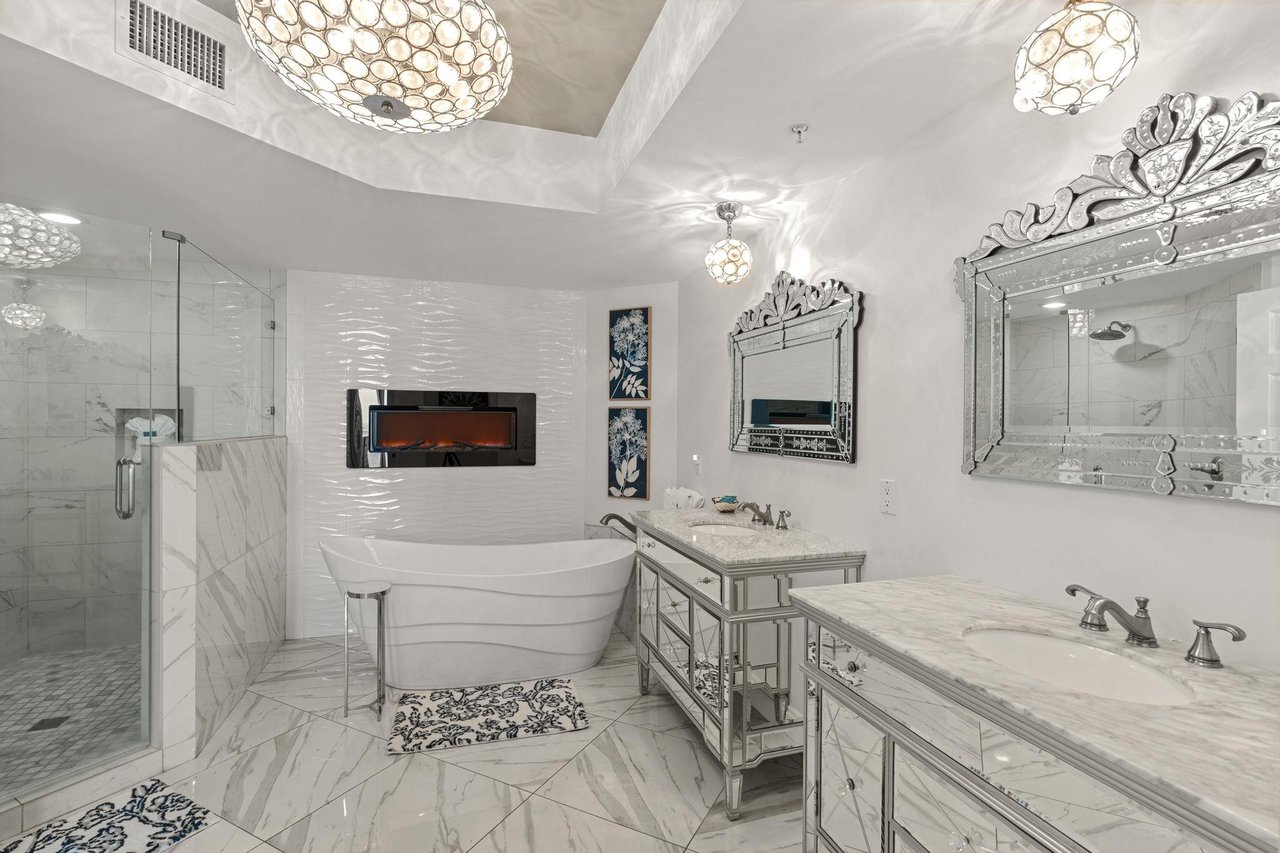 Step into your private spa sanctuary featuring a luxurious soaking tub, elegant marble surfaces, and stunning pendant lighting that creates the perfect ambiance.