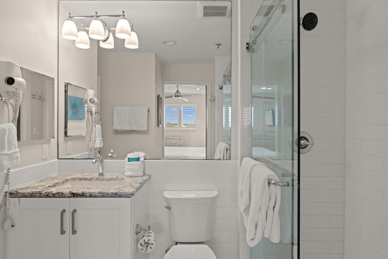 1st Floor Bathroom 1  Shared Bath  Step into your bathroom with pristine white subway tiles, a walkin glass shower, and a granite vanity. Fresh towels, and a wallmounted hairdryer.