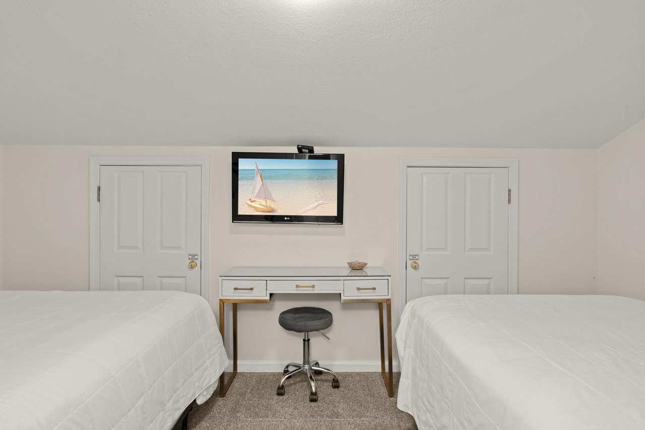 Two plush beds await your arrival, with a workspace in between for any essentials and a flatscreen TV to unwind with after your adventures.