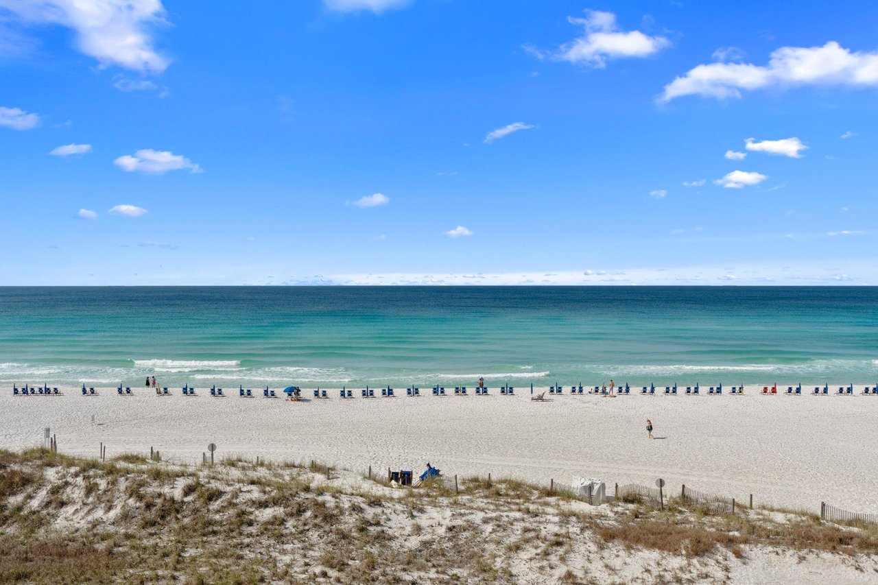 Pristine white sand beach with turquoise waters stretches along the propertys location, offering a stunning Gulf Coast setting for a relaxing coastal getaway.