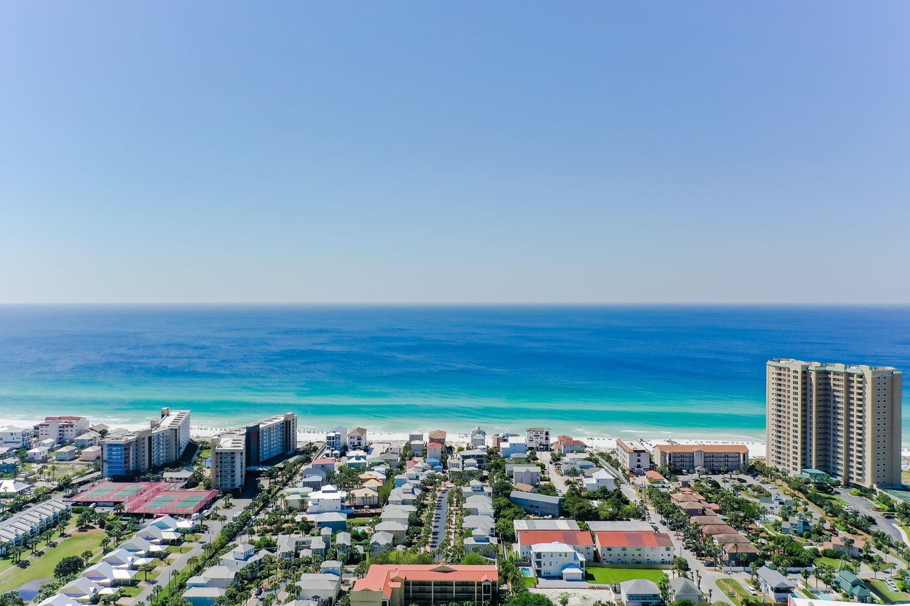 A stunning coastal community meets pristine turquoise waters along this beautiful shoreline, showcasing the vibrant beachfront neighborhood and surrounding area.
