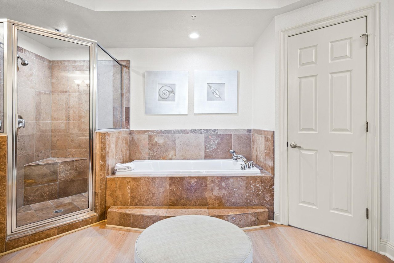 Unwind in the primary bathroom, with a soaking tub and spacious tiled shower—perfect for relaxing after a full day of adventures.