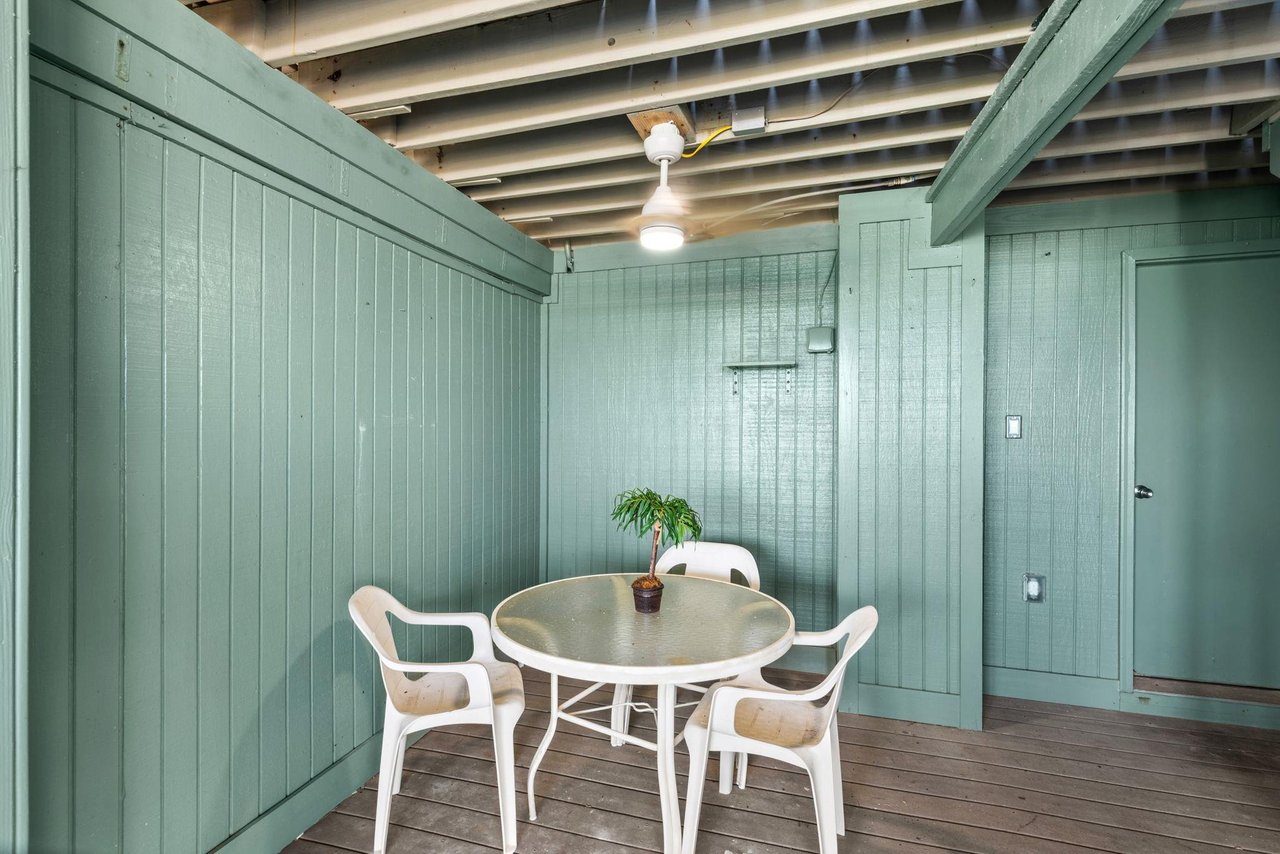 Covered patio with table and chairs for card games or cocktails and an outdoor shower to rinse the days sand away