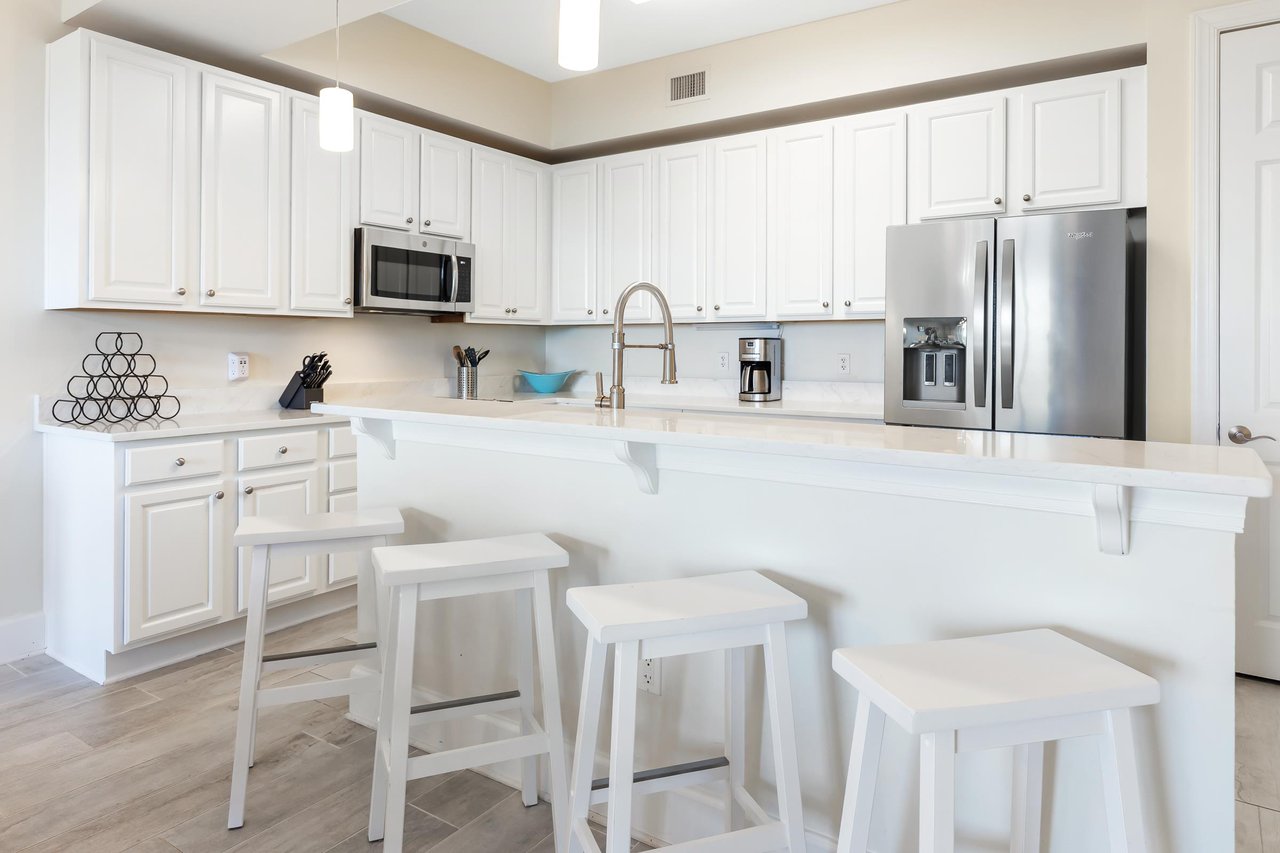 Bright, modern kitchen with gleaming countertops, stainless steel appliances, and a welcoming island where you can gather for meals or morning coffee.
