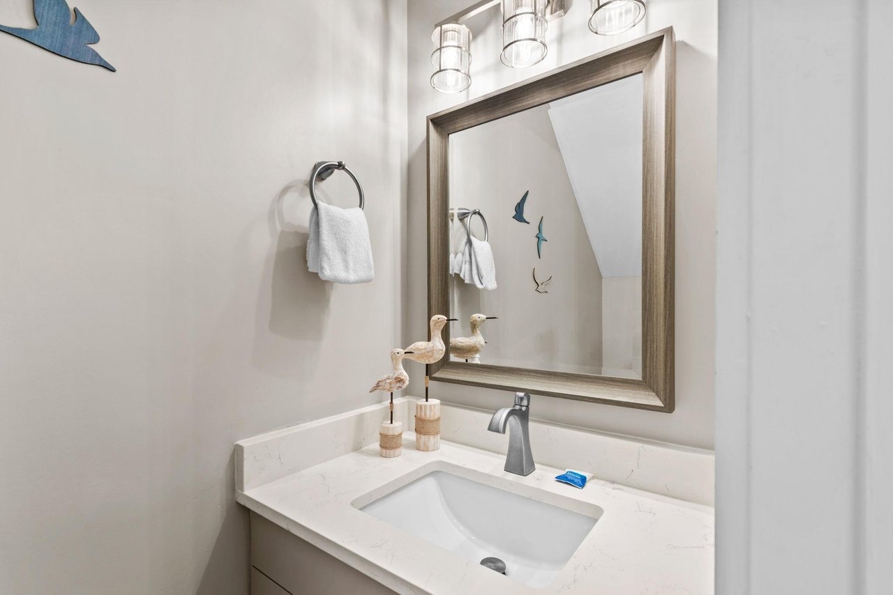 Step into your thoughtfully designed bathroom with coastal charm and modern fixtures. Fresh towels await your arrival.