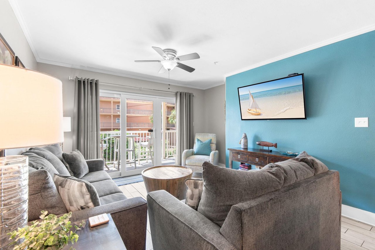 Unwind in your bright living room with plush seating, breezy ceiling fan, and coastal touches that set the tone for your beach getaway.