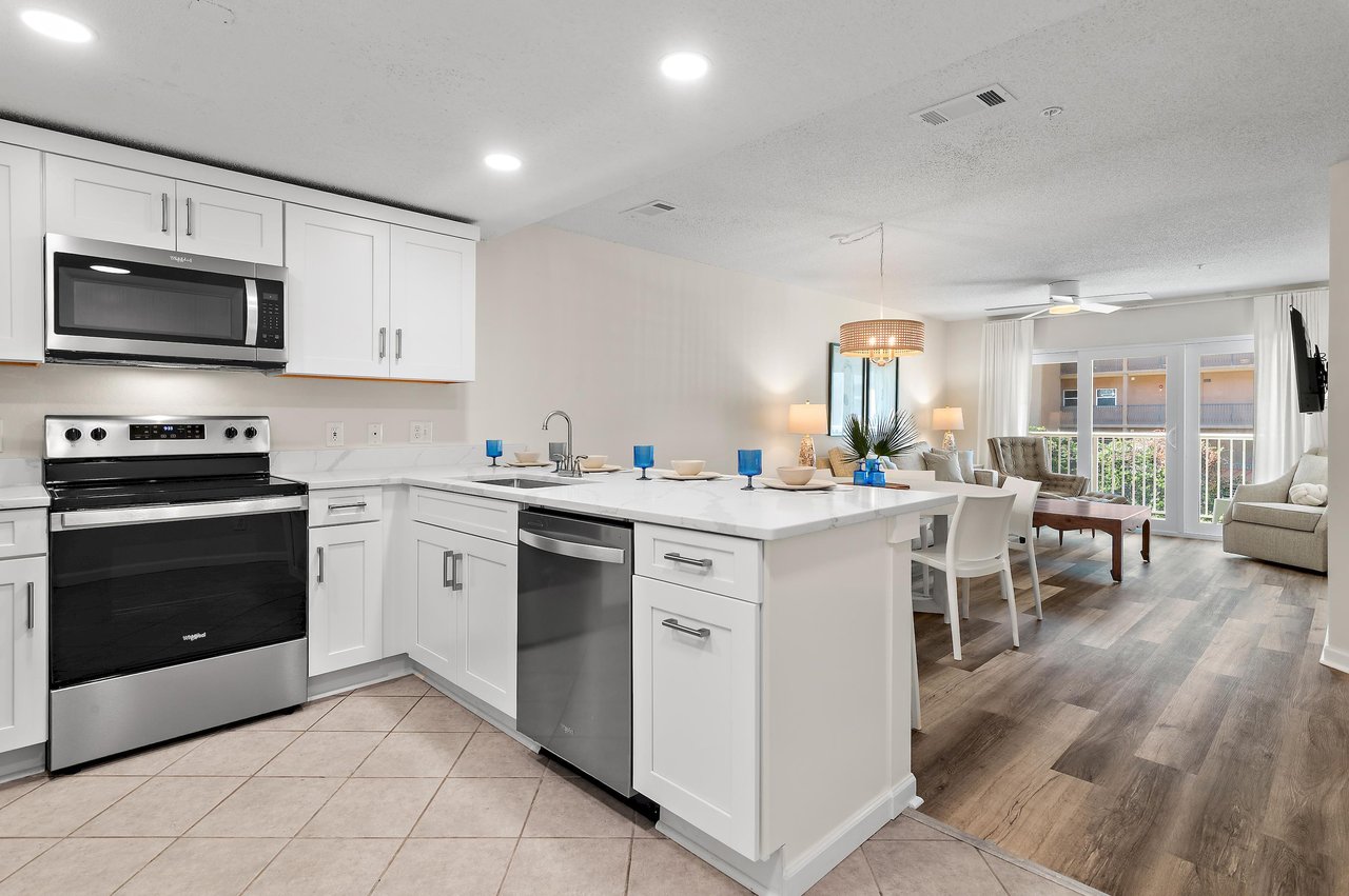 Step into your bright, openconcept space where cooking and gathering blend seamlessly. The modern kitchen flows into a welcoming dining and living area, with natural light streaming through the glass