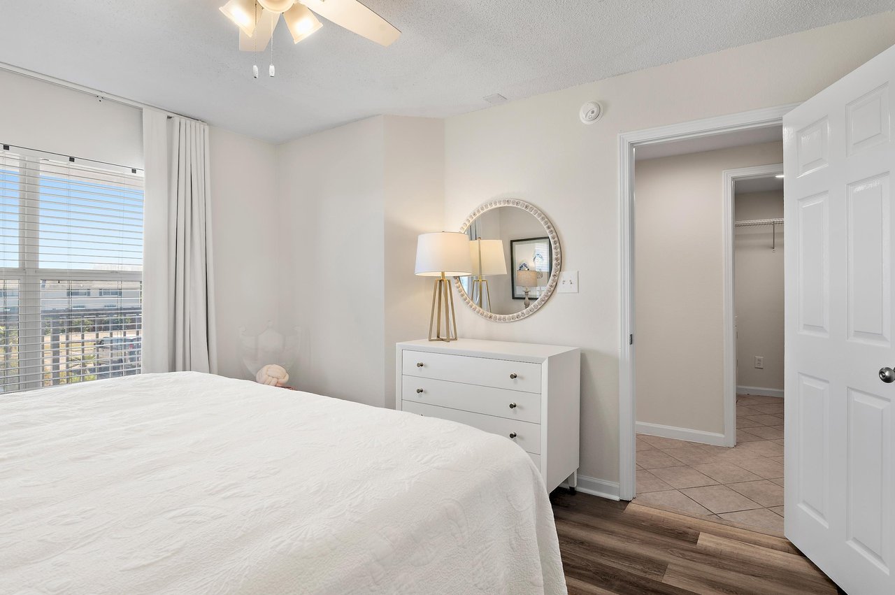 Wake up in this serene bedroom with bright natural light and a gentle ceiling fan overhead. Your closet awaits, and a glimpse of surrounding city rooftops reminds you youre in the heart of it all.