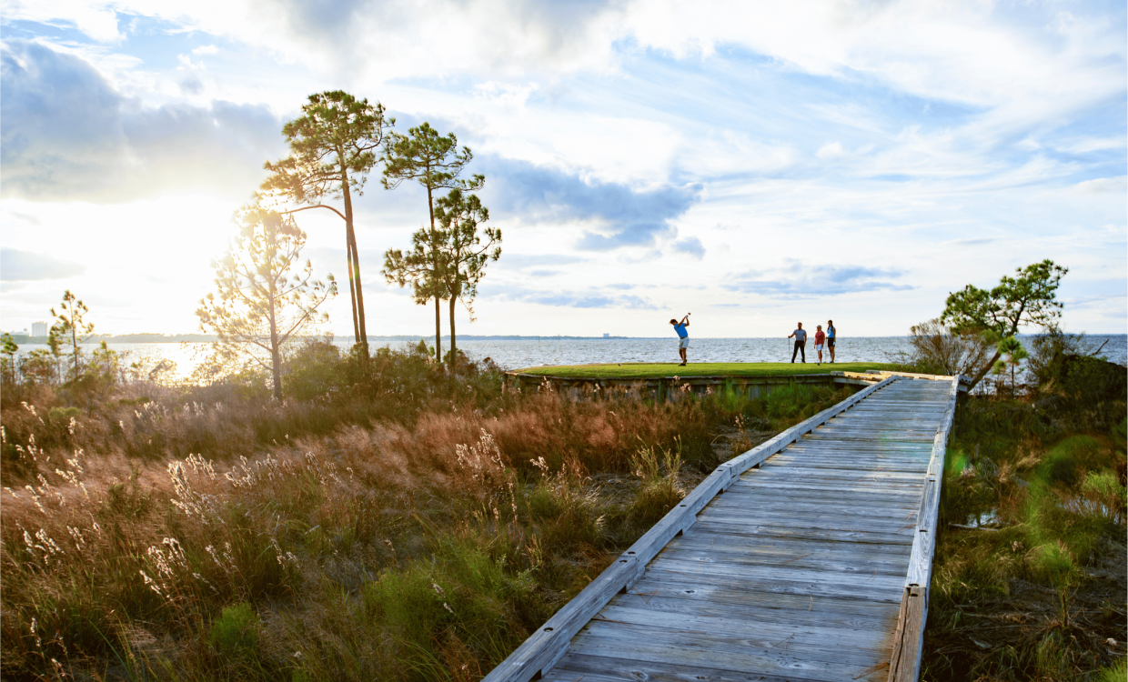 2268593 A Group Of People Walking On A Path By A Body Of Water