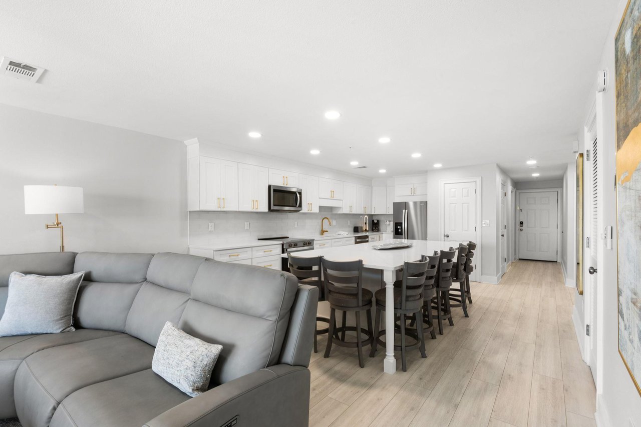 Relax in your bright openplan living space, where a sleek kitchen with stainless appliances flows into a cozy living area and dining island perfect for gathering with loved ones.