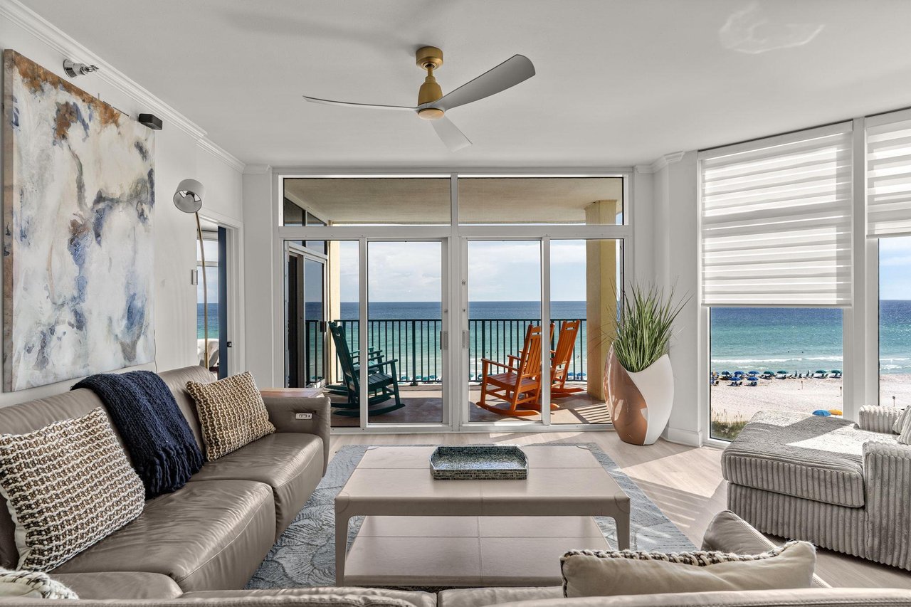 Sink into plush seating and gaze at turquoise waves framing your private balcony, where rocking chairs invite you to savor sunrise coffee or evening cocktails just steps from the sand.