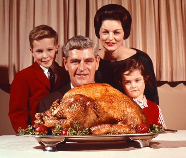 a group of people posing for a photo with a large turkey