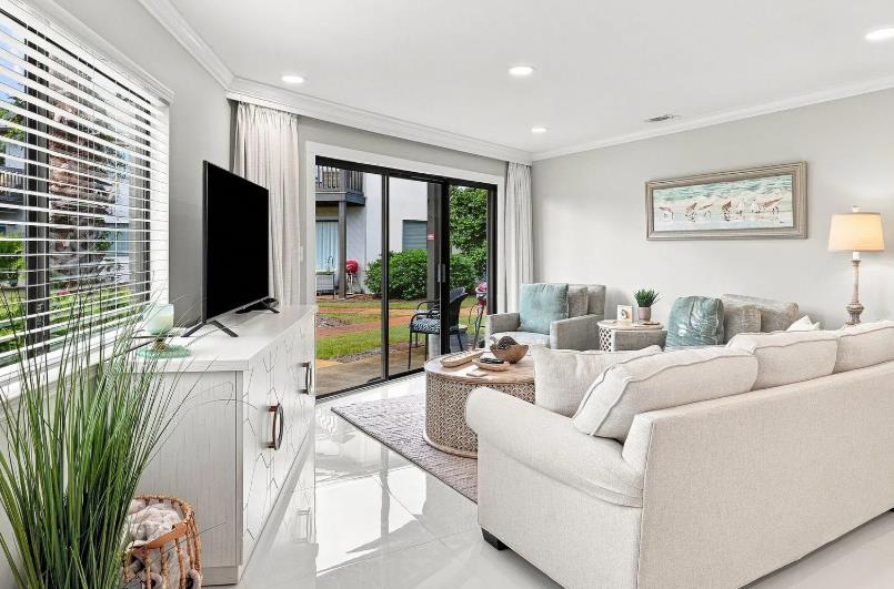 Natural light pours through the windows, illuminating a cozy seating area perfect for your morning coffee or evening relaxation.