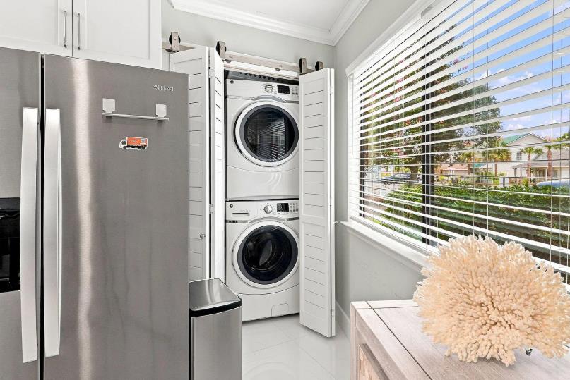 Your laundry essentials are neatly tucked behind elegant barn doors, with modern appliances and bright windows making chores feel effortless.