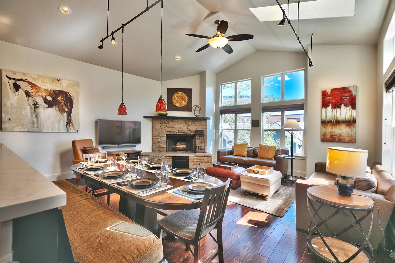 Stunning great room with vaulted ceilings, impressive window wall, open floor plan with dining room, living room, and kitchen