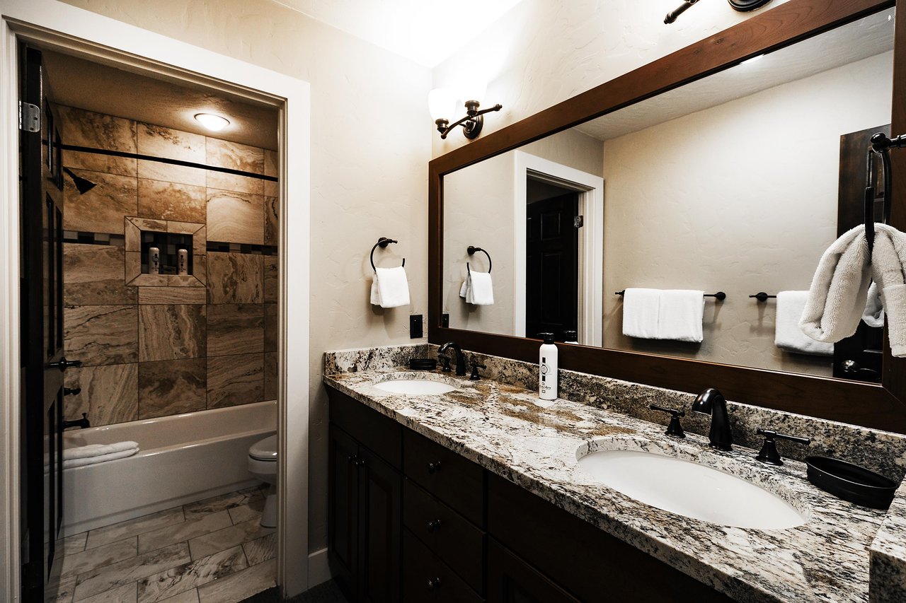 Full bathroom in the den with dual vanity, granite countertops