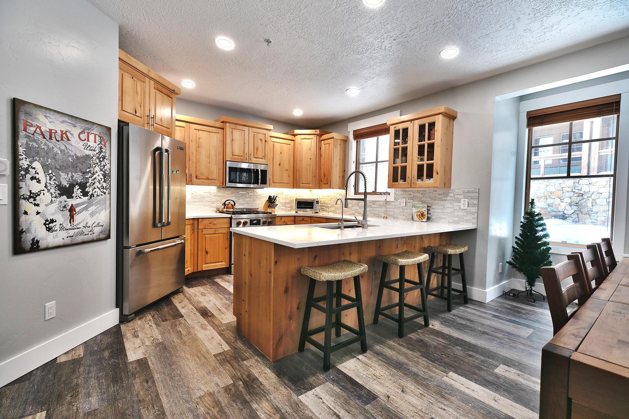 Hardwood floors in the fully equipped kitchen, kitchen has breakfast bar overlooking the living room