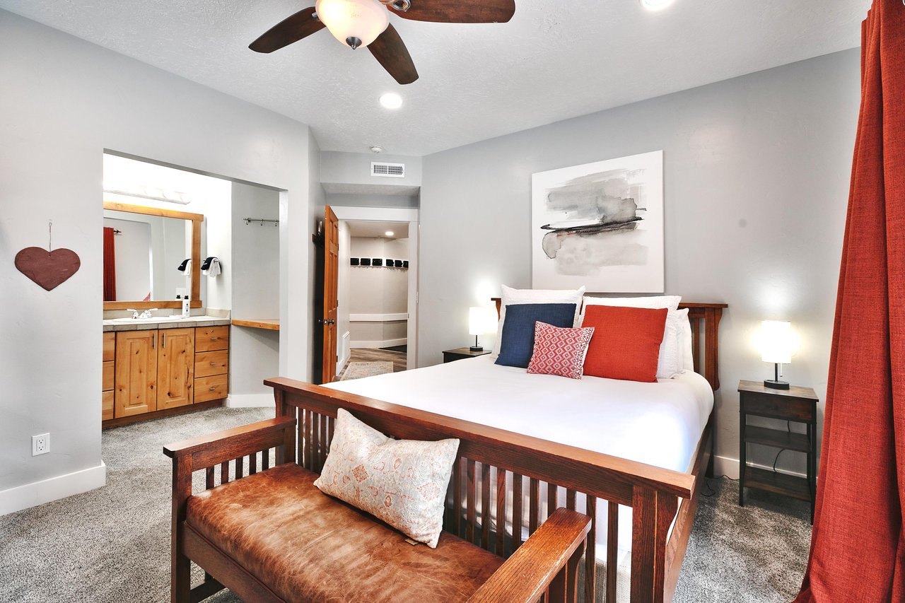 Guest bedroom with queen bed, wooden bedframe and leather and wooden bedroom  bench