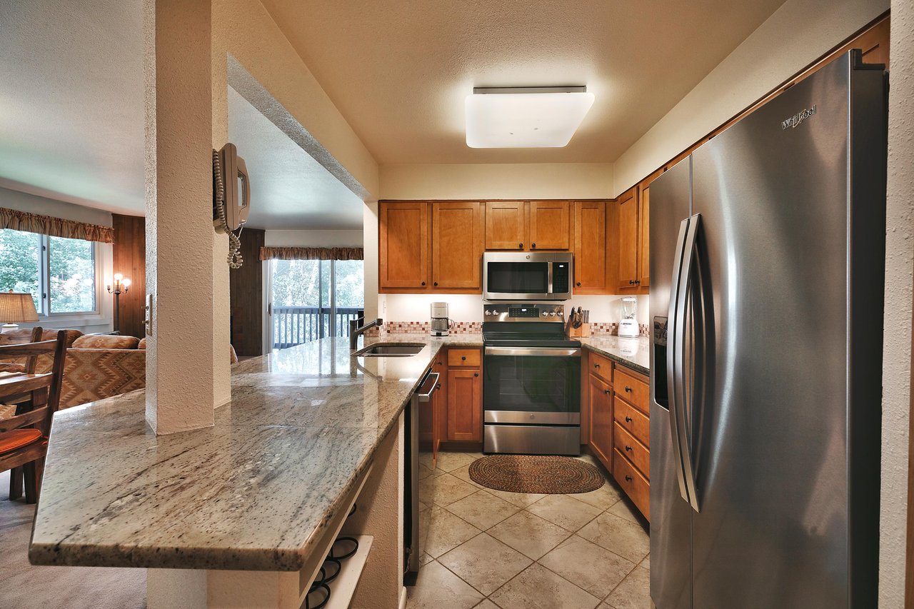 Kitchen with french door stainless steel refrigerator, chrome stove and granite countertops