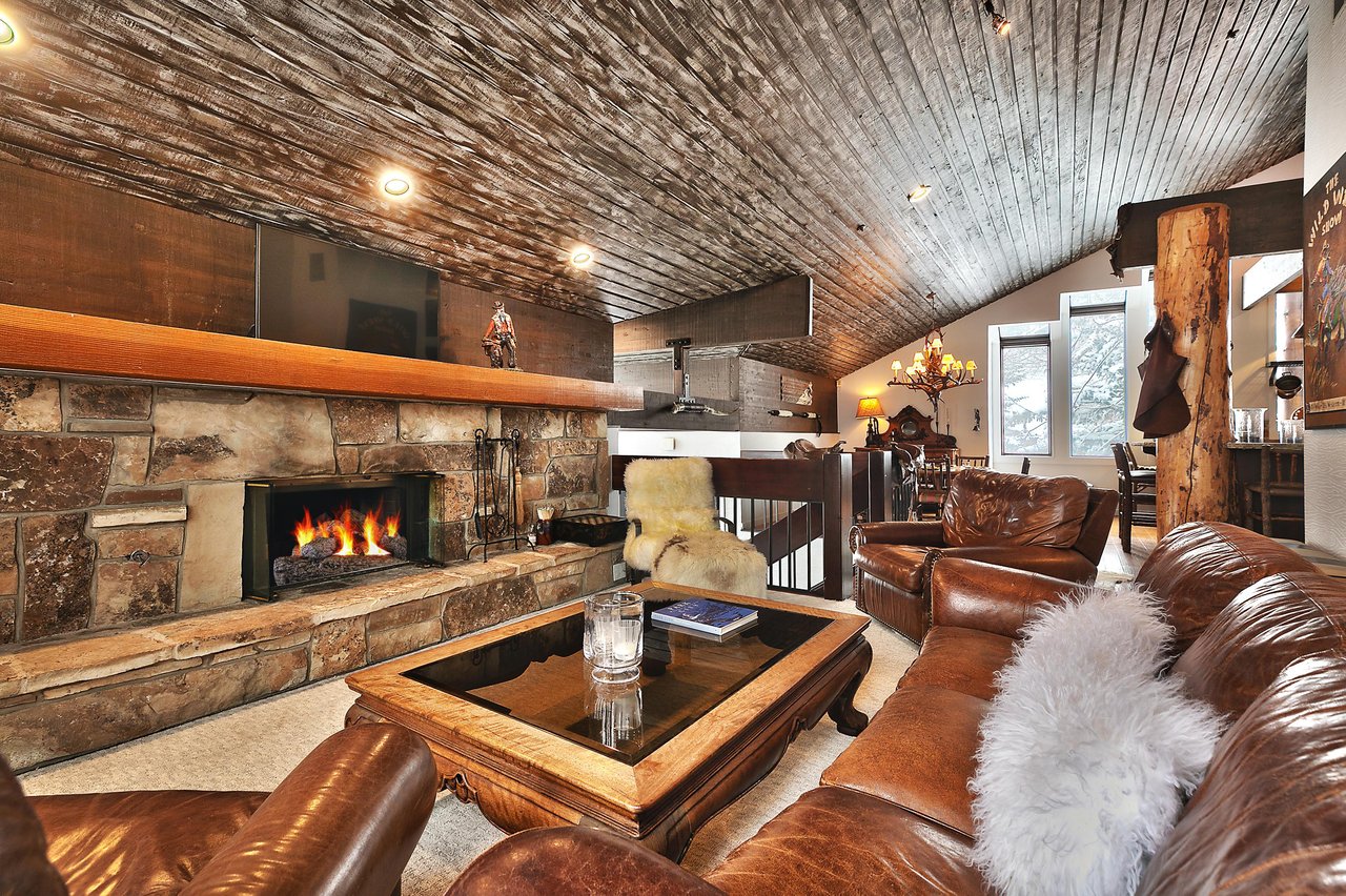 Striking wooden mantle over the wood burning fireplace in the flagstone hearth in the living room