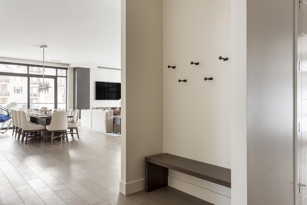 Lift 601 entryway with wall hooks and wooden bench opening to the dining and living room