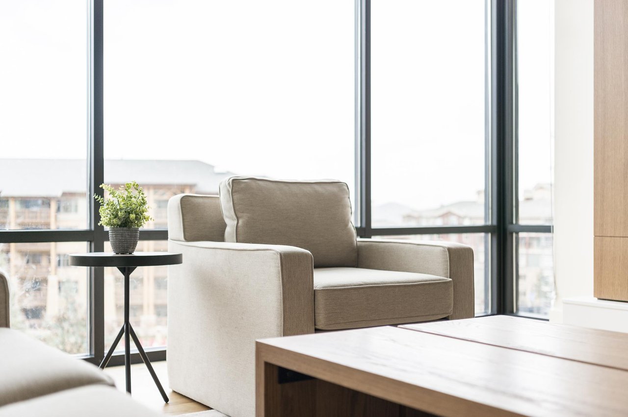 Mountain modern design, accent armchair in the living room with abundant natural light from window walls