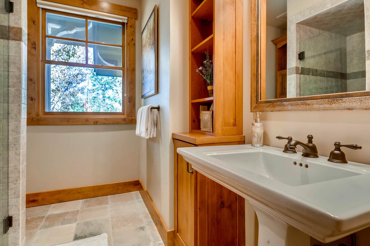 Full guest bath, slatestone tiled floor, and large picture window