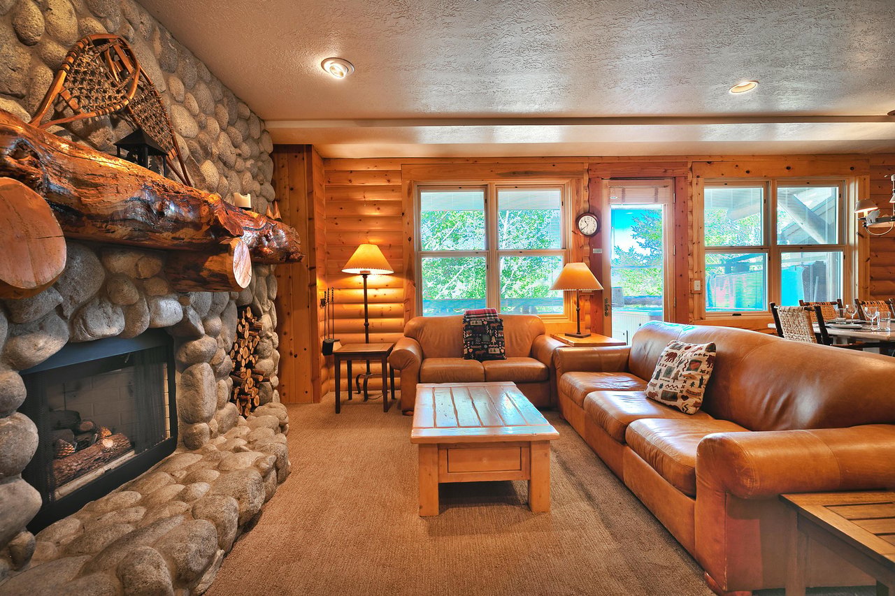 Bright picture windows line the western wall of the condo, two cozy couches in the living room