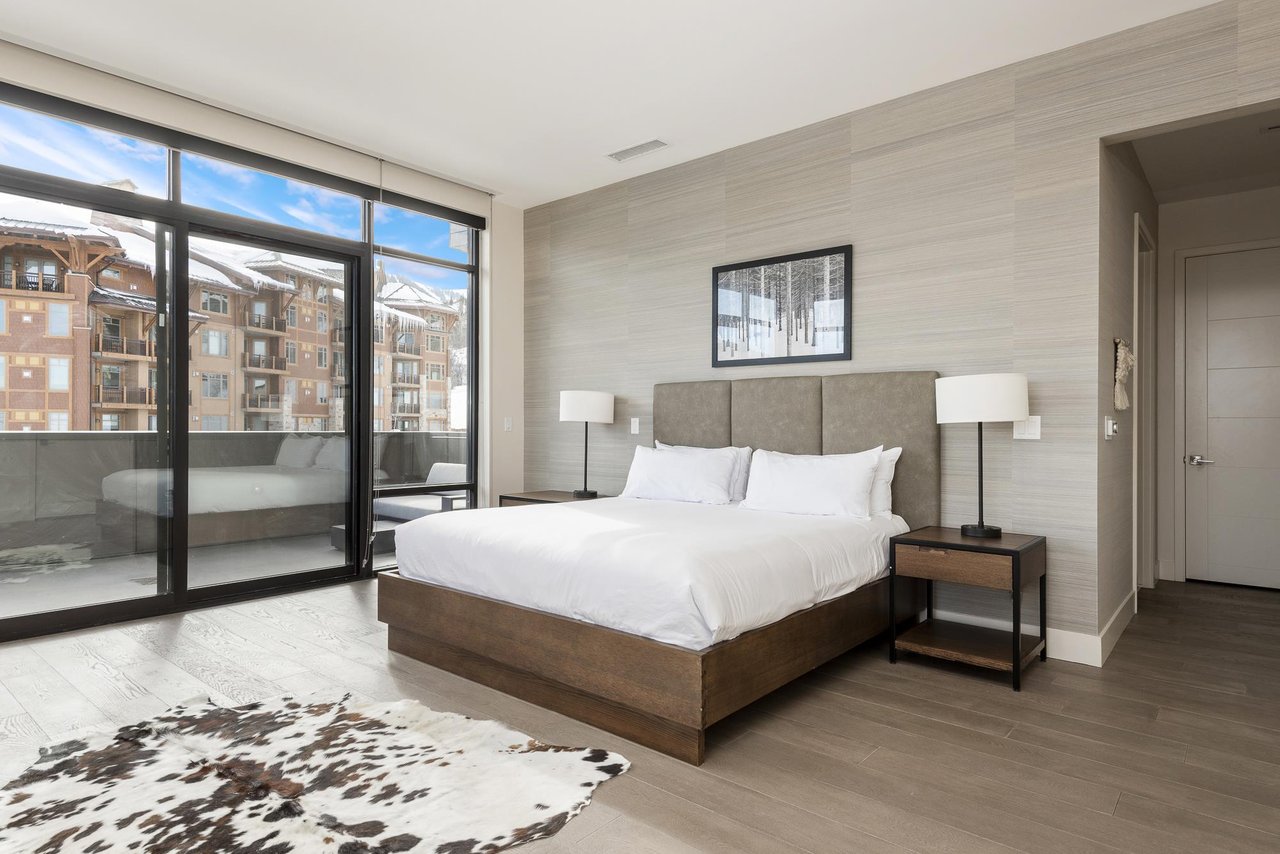 Luxurious king bed, wooden platform bedframe, hardwood floors and cowhide area rug